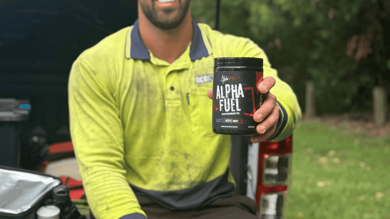 tradie in back of ute with a supplement in hand 